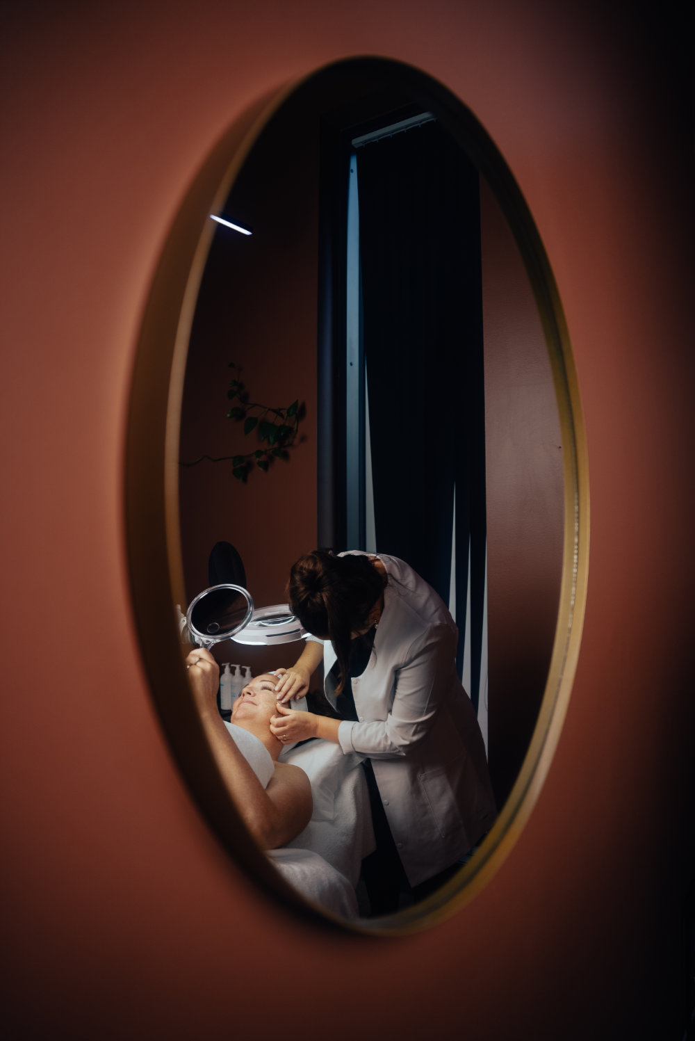 Pasient ser på ansikt med speil, Dermatolog behandler ansikt